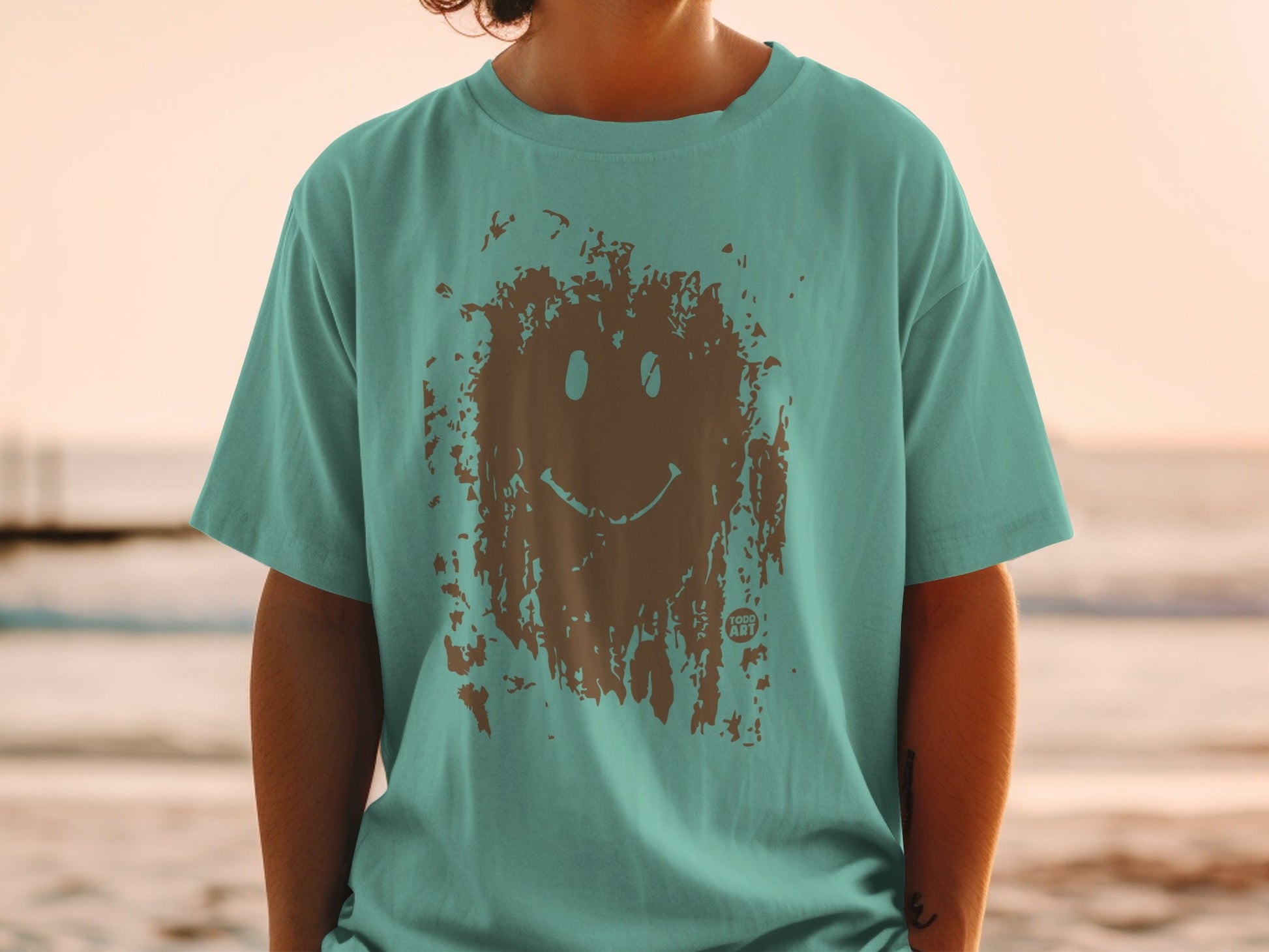 Teal t-shirt with distressed brown smiley face graphic.