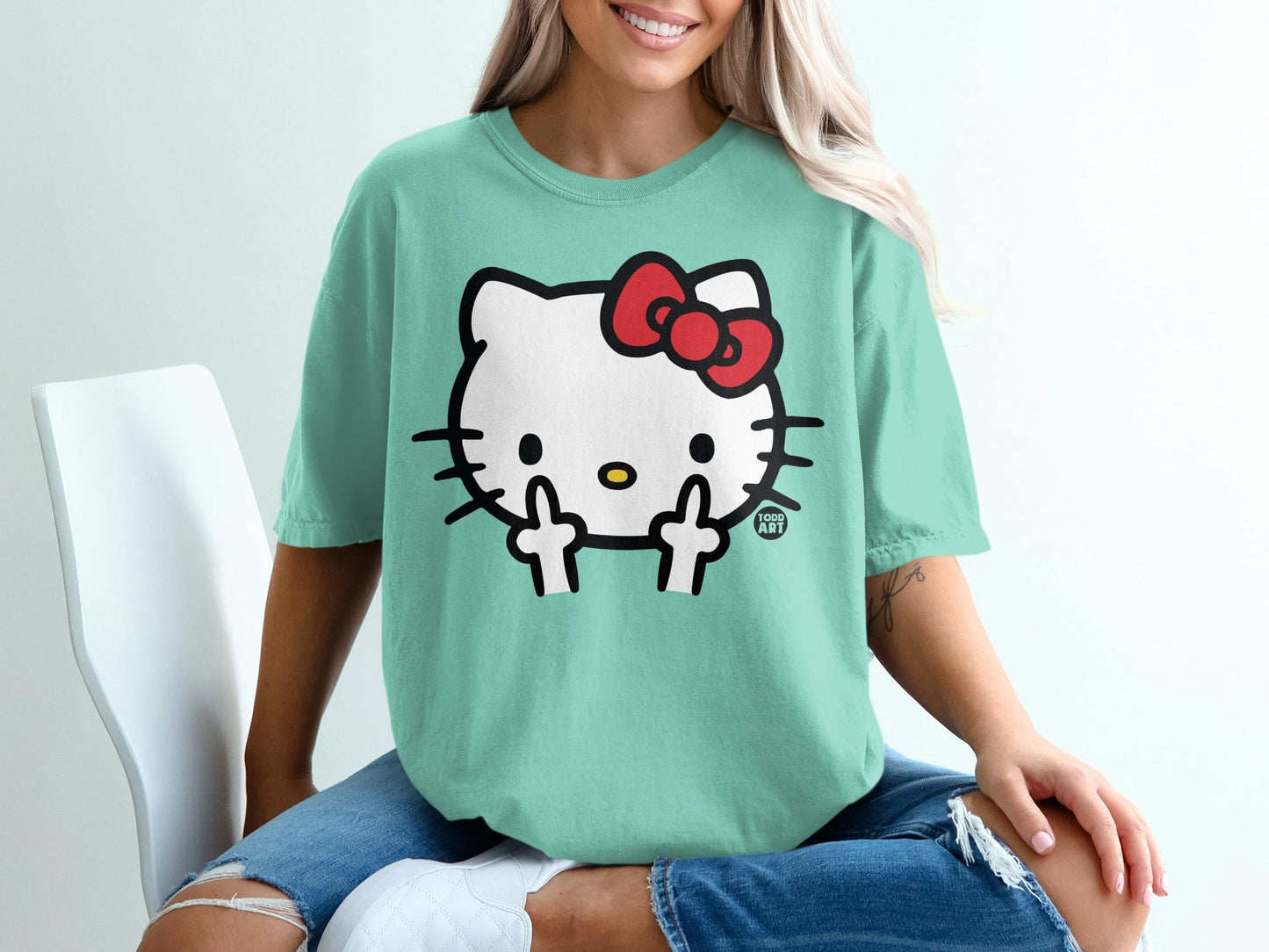Mint green t-shirt with Hello Kitty giving middle finger gesture.