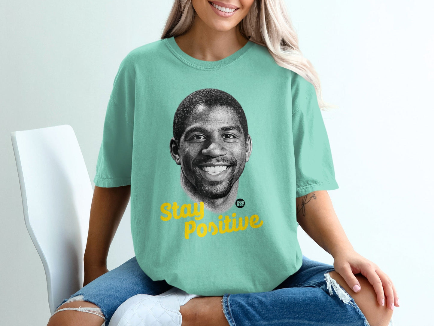 Man in mint green t-shirt with "Stay Positive" text and Magic Johnson portrait.