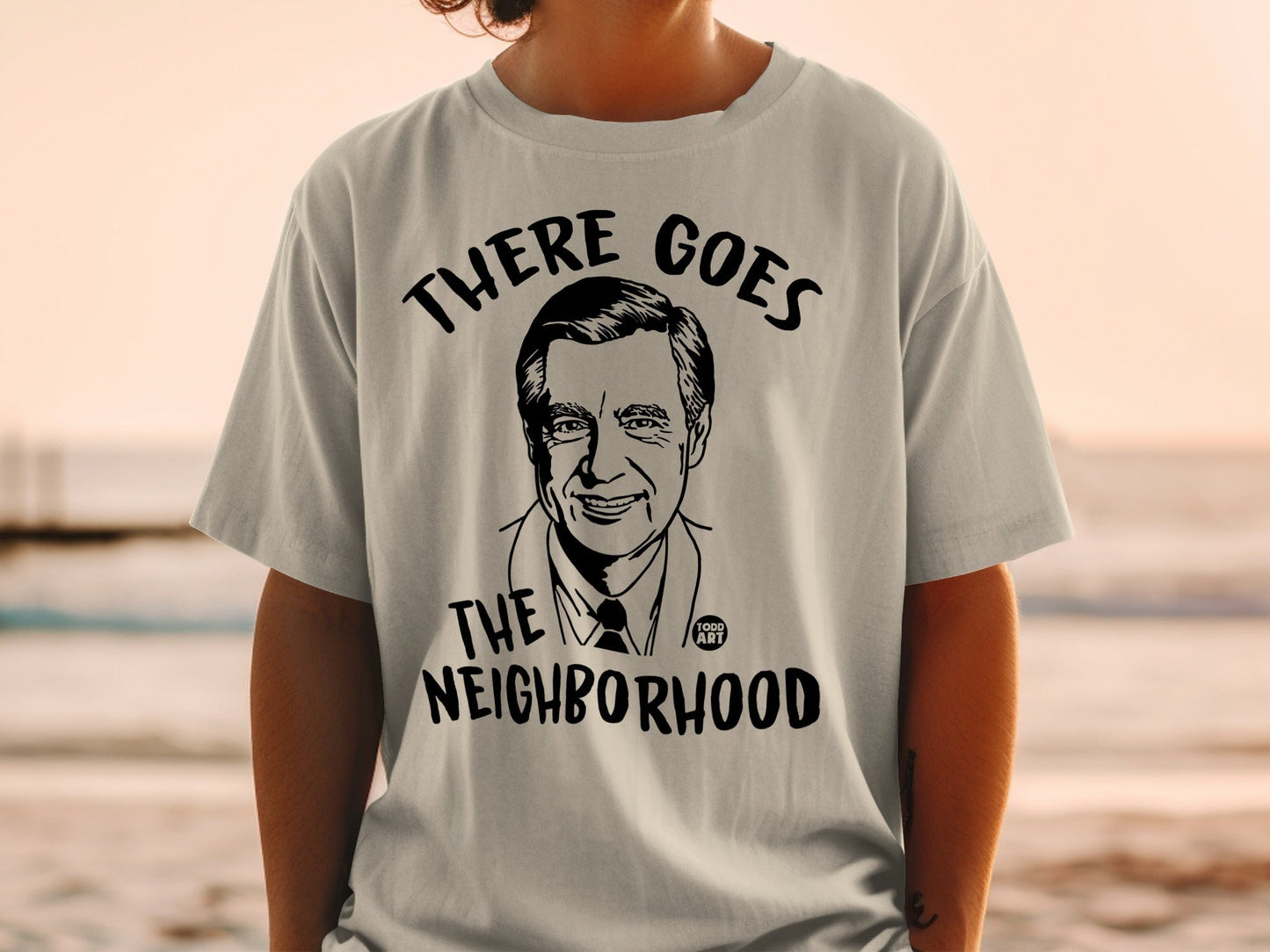 T-shirt with black graphic of Fred Rogers and "THERE GOES THE NEIGHBORHOOD" text.