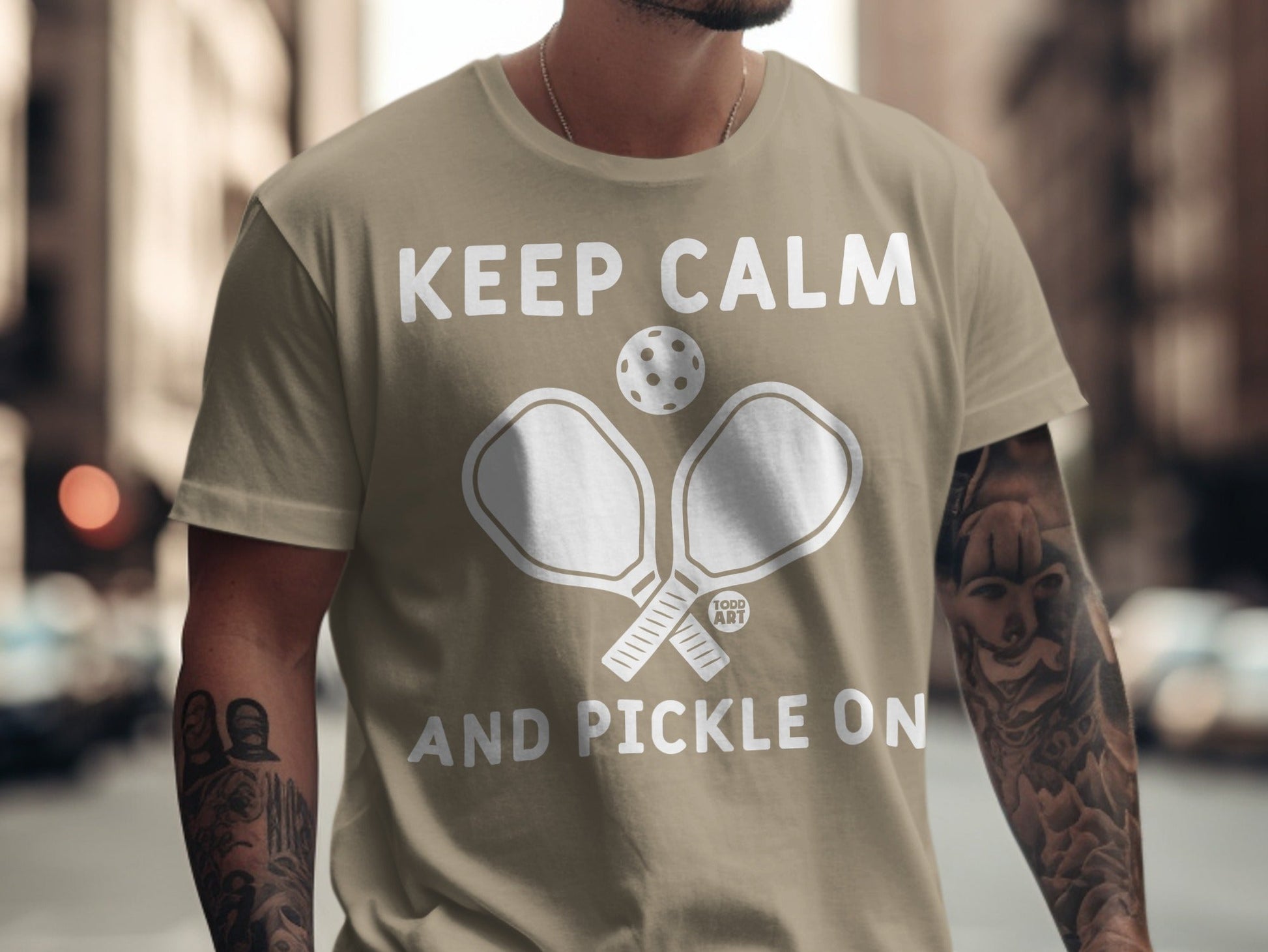T-shirt with "Keep Calm and Pickle On" text and pickleball paddles.