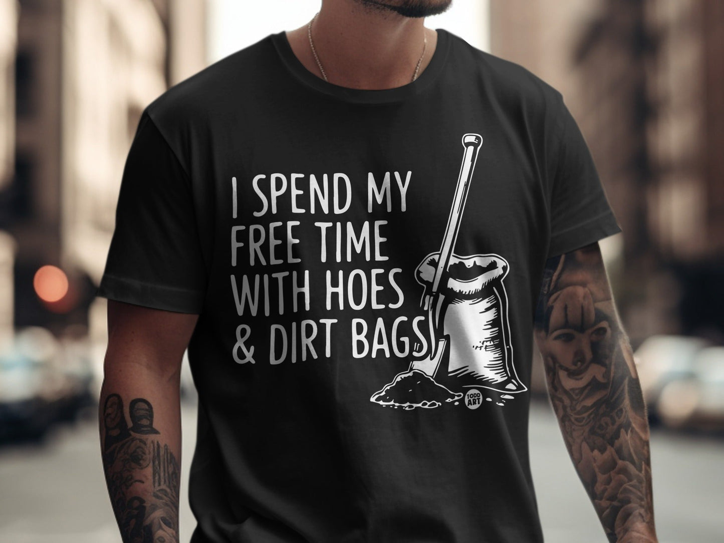 Black t-shirt with text "I SPEND MY FREE TIME WITH HOES & DIRT BAGS" and illustration.