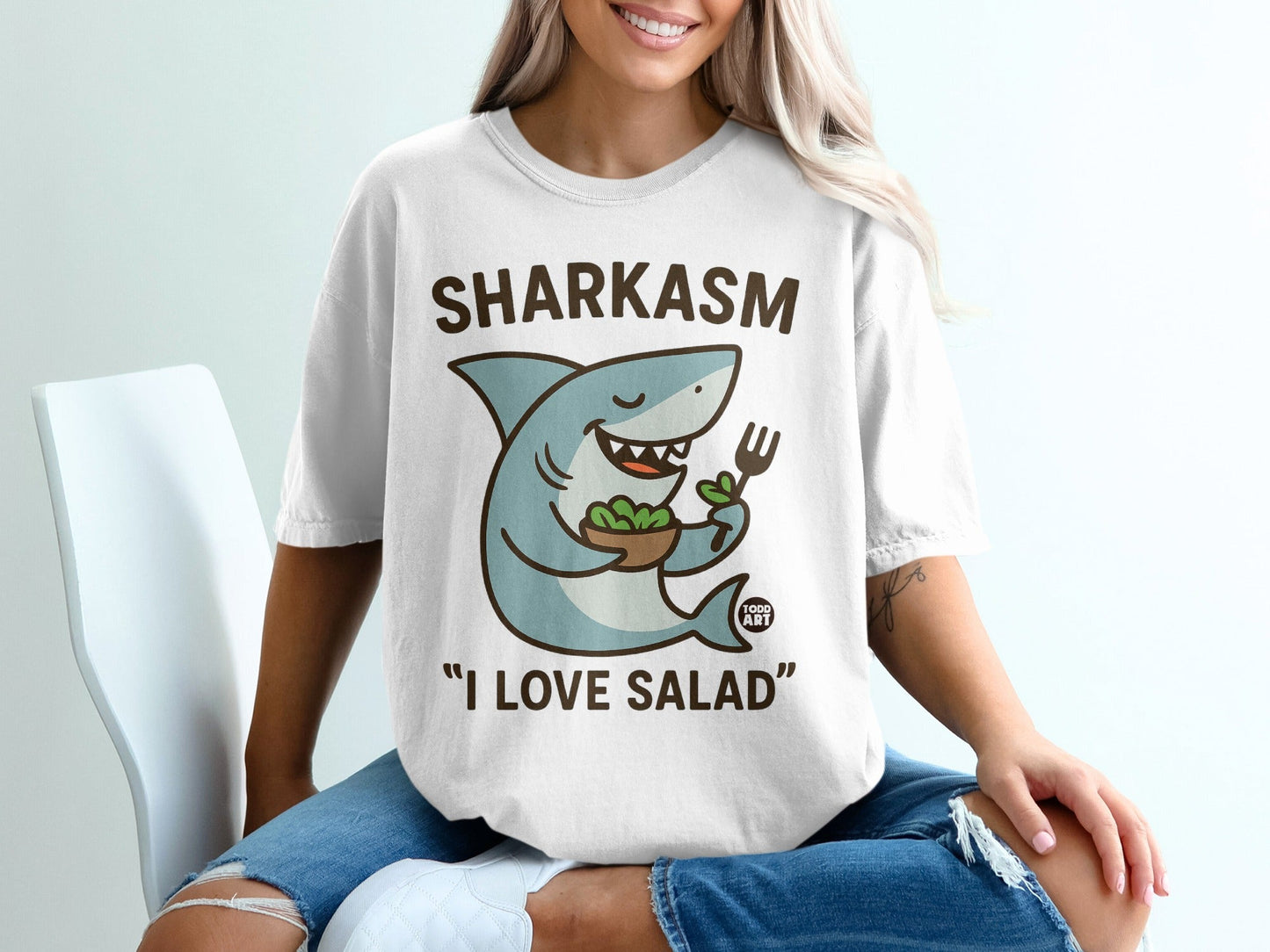 Cartoon shark in a t-shirt holding a salad bowl, "Sharkasm I Love Salad."