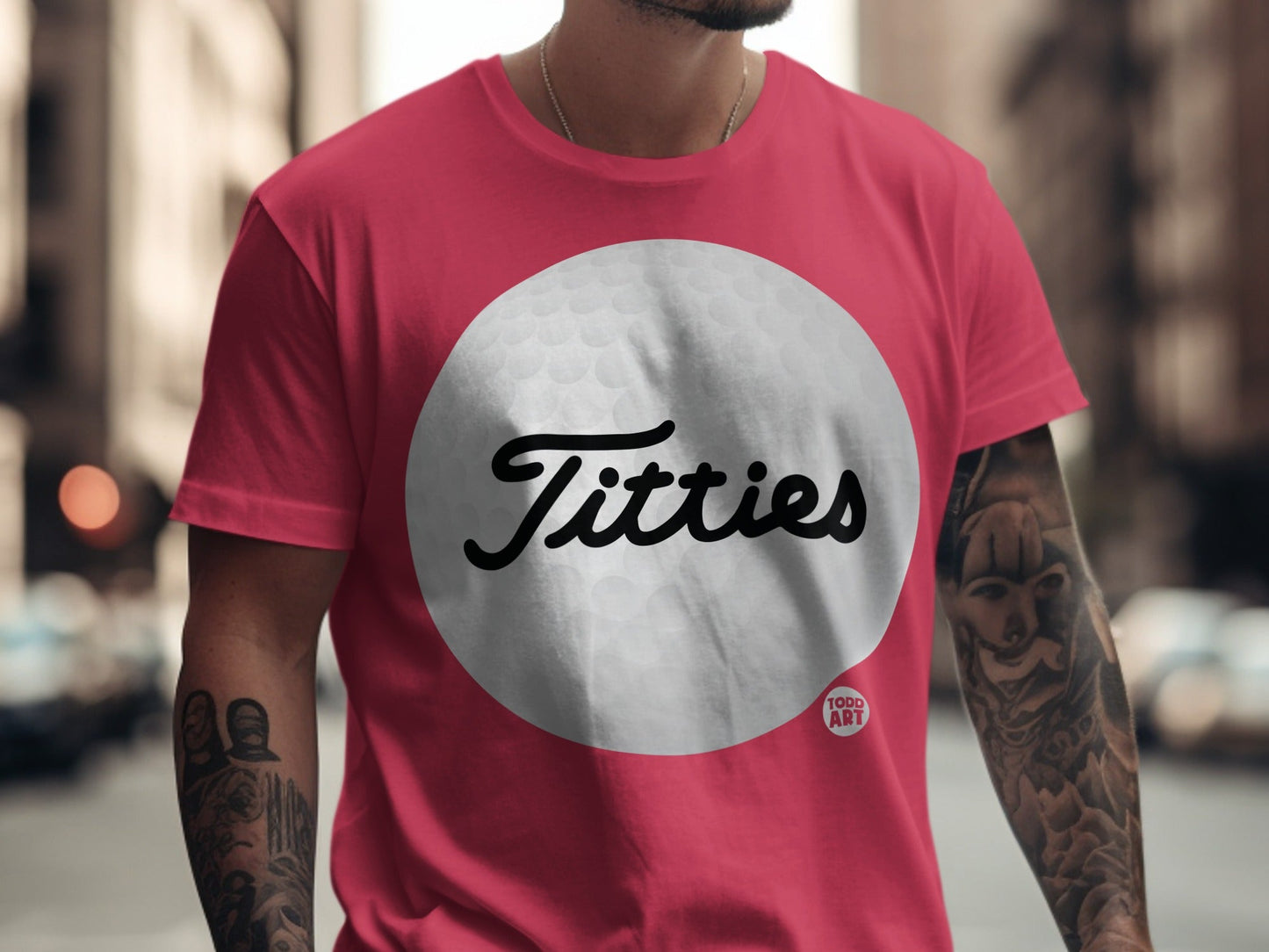Pink t-shirt with "Titties" logo on a golf ball graphic.