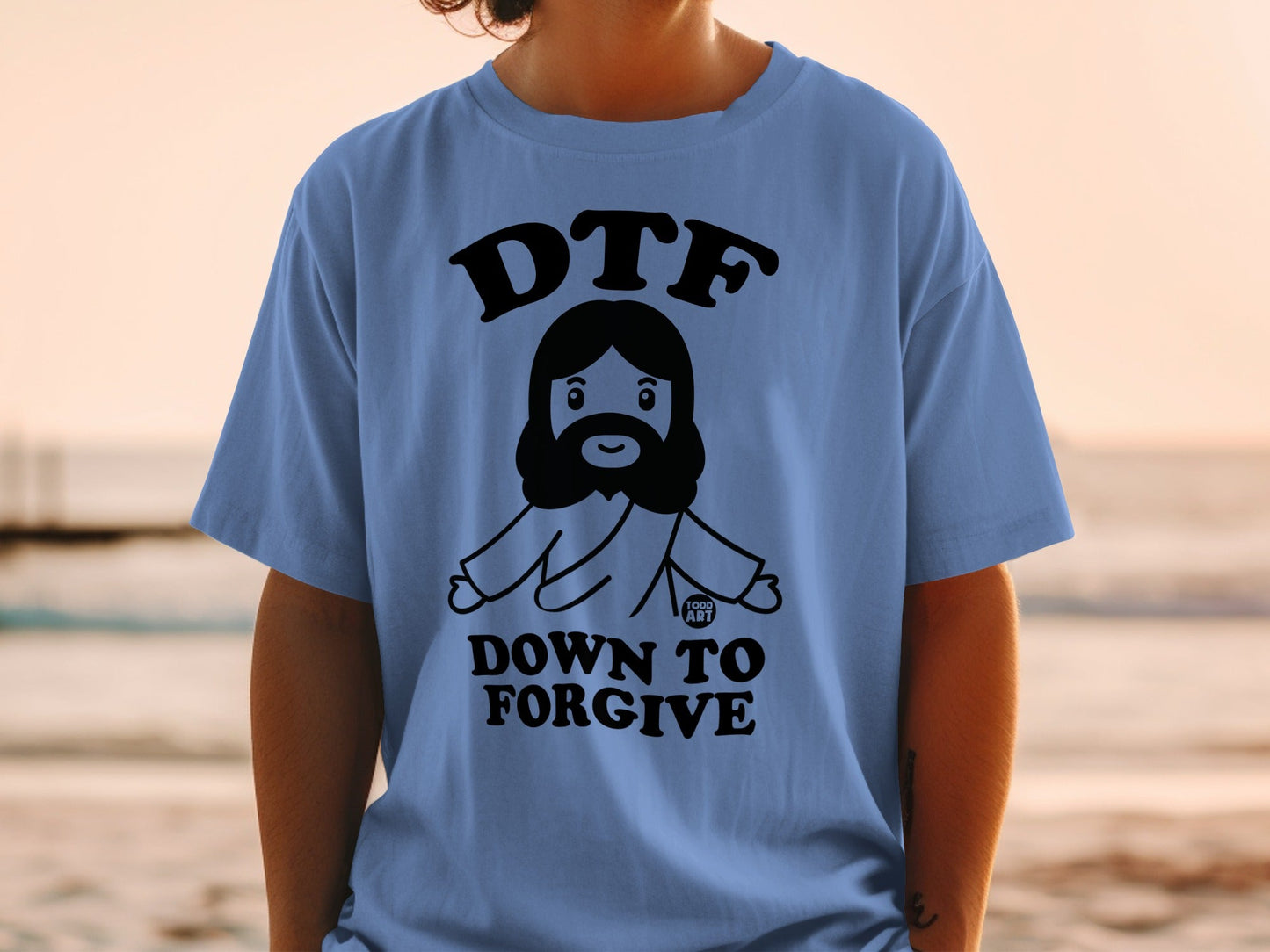 Blue t-shirt with "DTF DOWN TO FORGIVE" text and cartoon Jesus graphic.