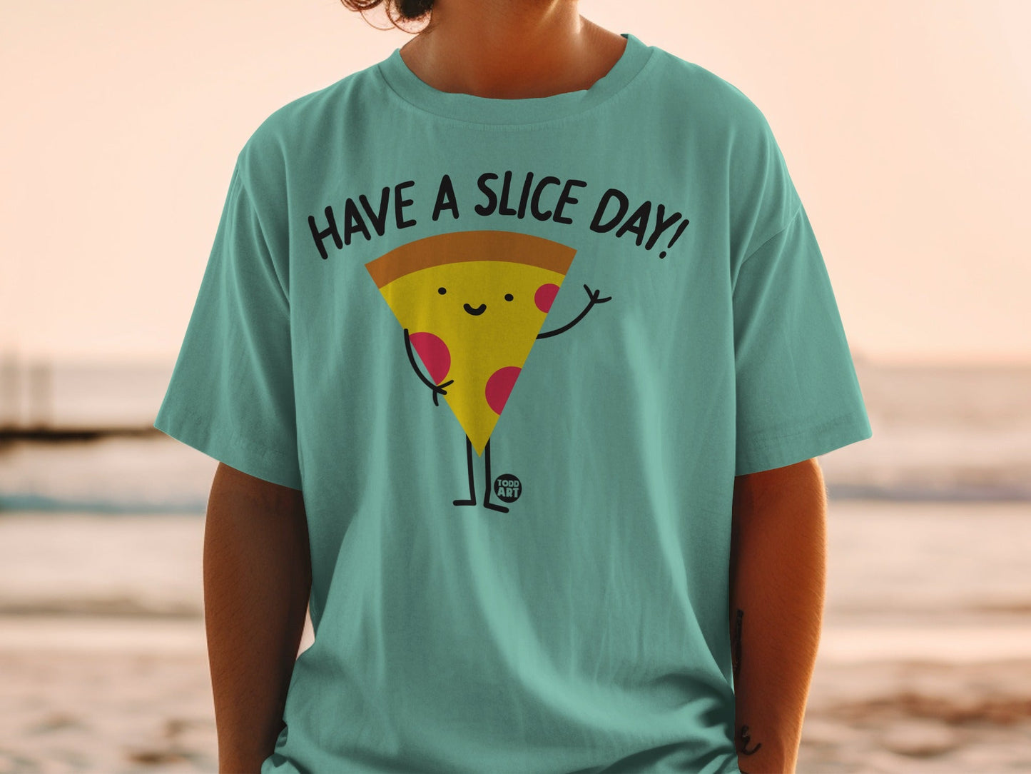 Teal t-shirt with a smiling pizza slice graphic saying "HAVE A SLICE DAY!".