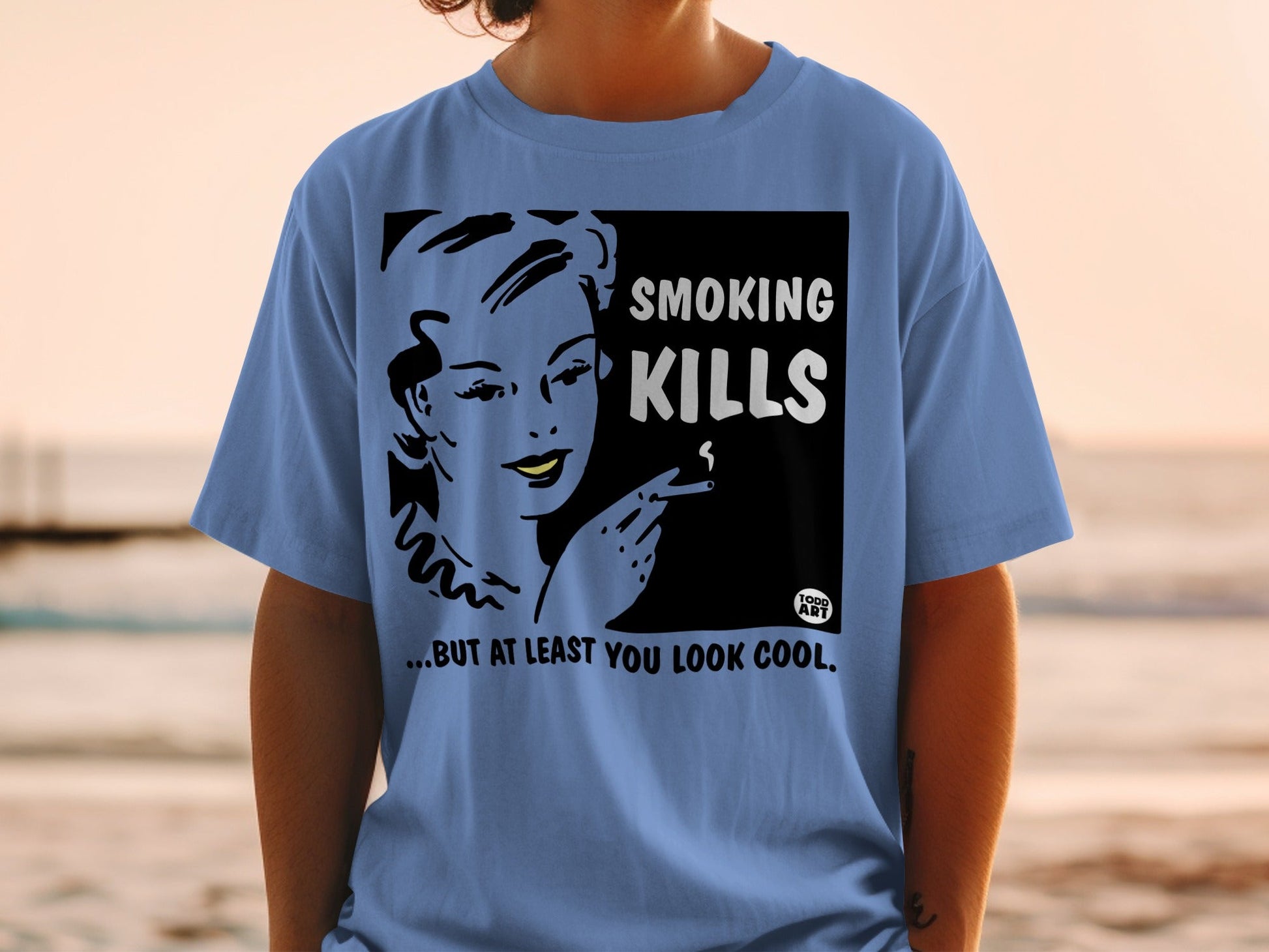 Blue t-shirt with "Smoking Kills... But At Least You Look Cool" graphic and woman smoking.
