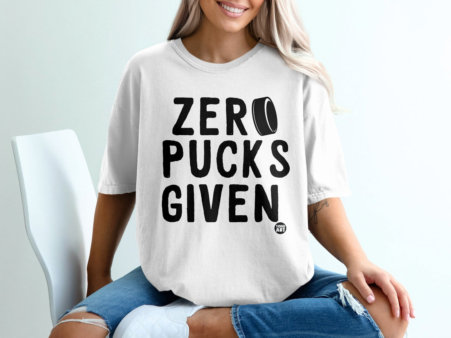 White t-shirt with "ZERO PUCKS GIVEN" text and hockey puck graphic.