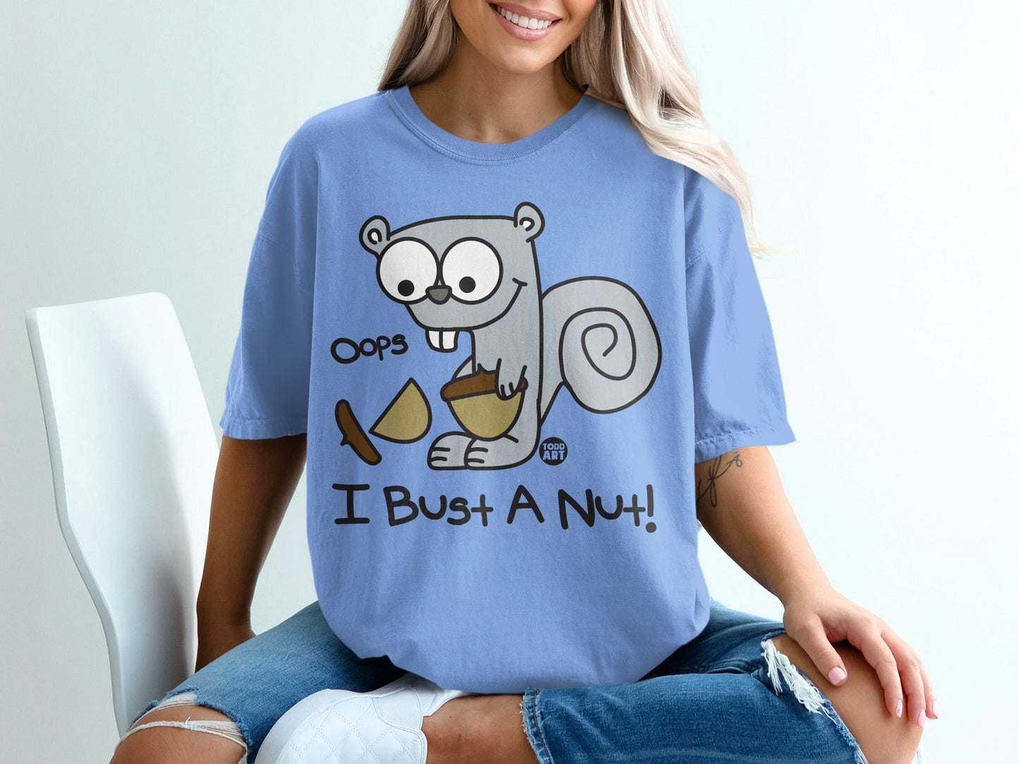 Blue t-shirt with a cartoon squirrel holding a nut, saying "Oops I Bust a Nut!"