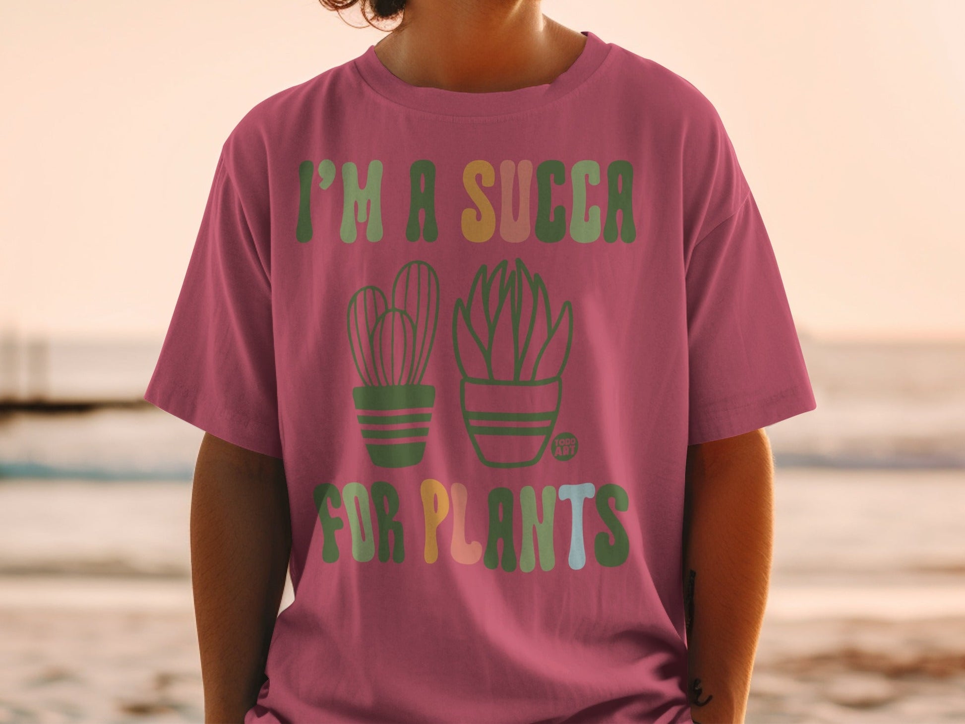 Pink t-shirt with "I'm a succa for plants" text and potted cactus and succulent graphics.