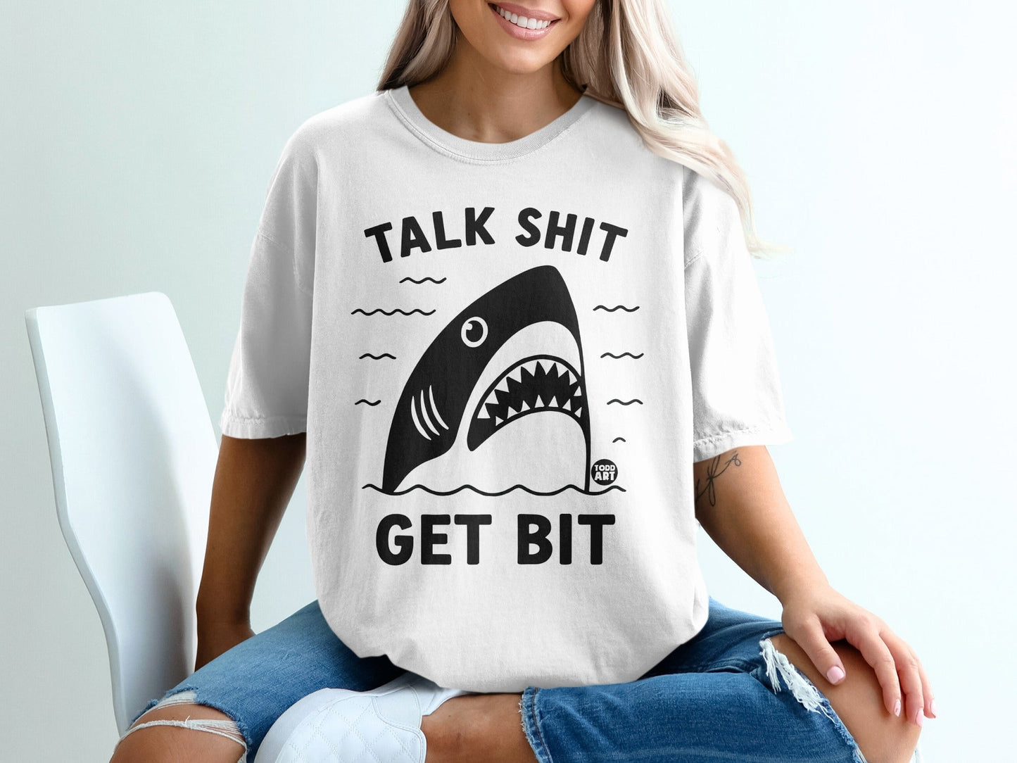 White t-shirt with black graphic of shark and text "TALK SHIT GET BIT".