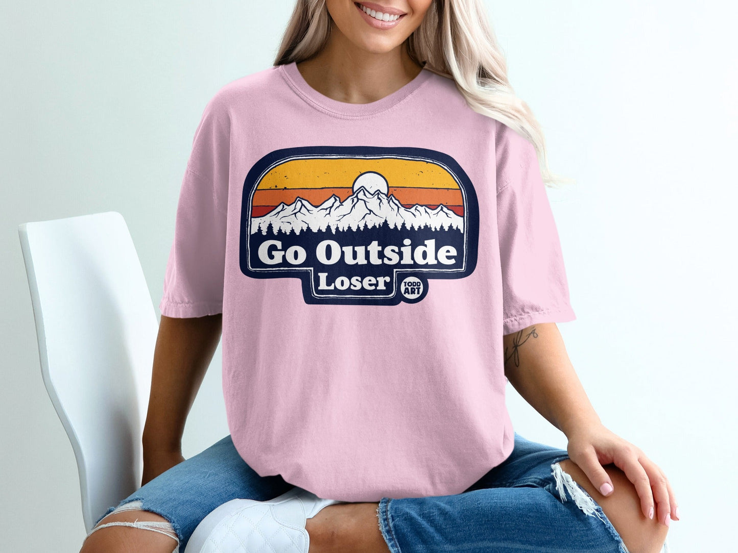 Pink t-shirt with "Go Outside Loser" text and mountain sunset graphic.