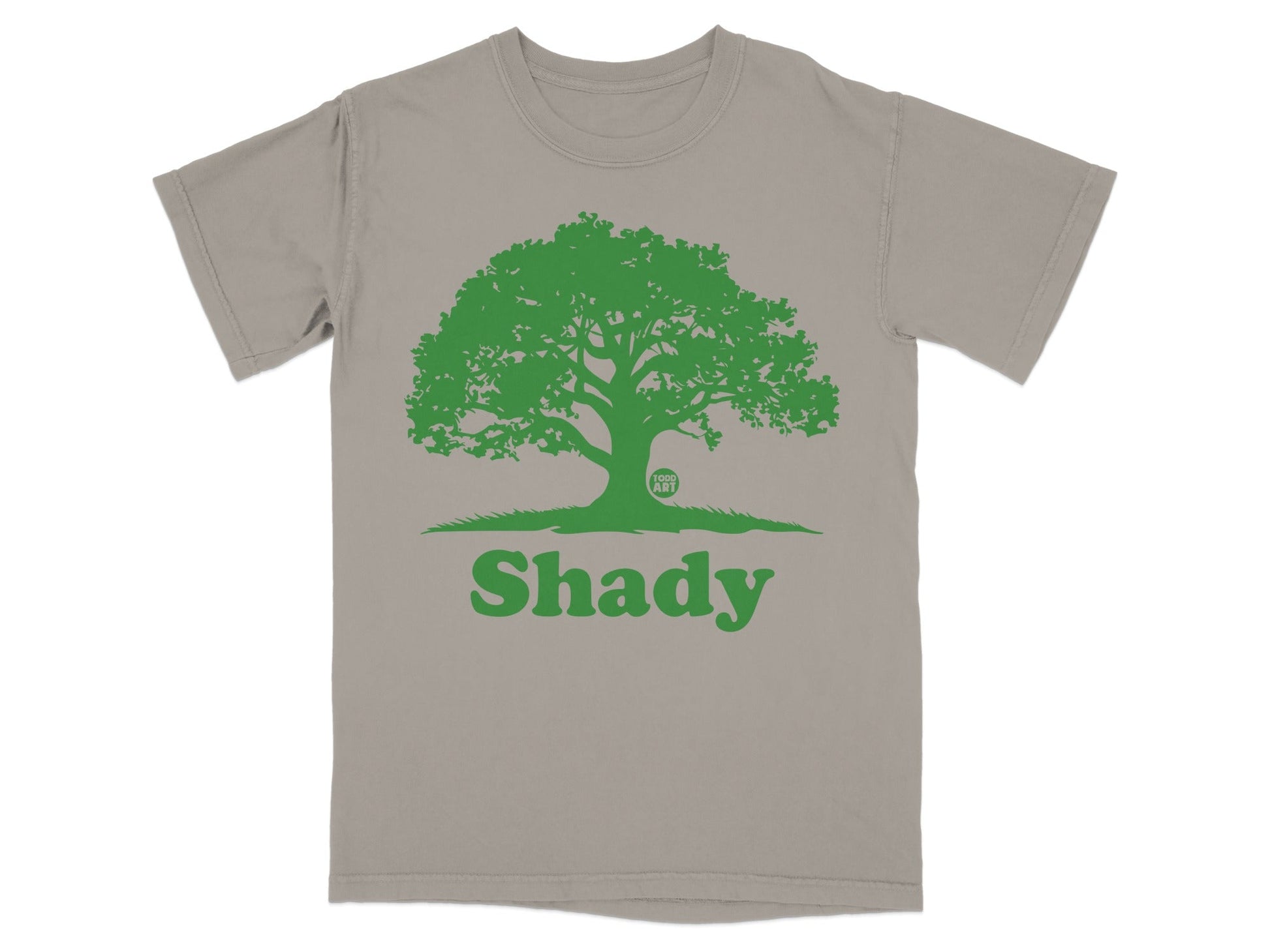 Green tree graphic with "Shady" text on a taupe t-shirt.