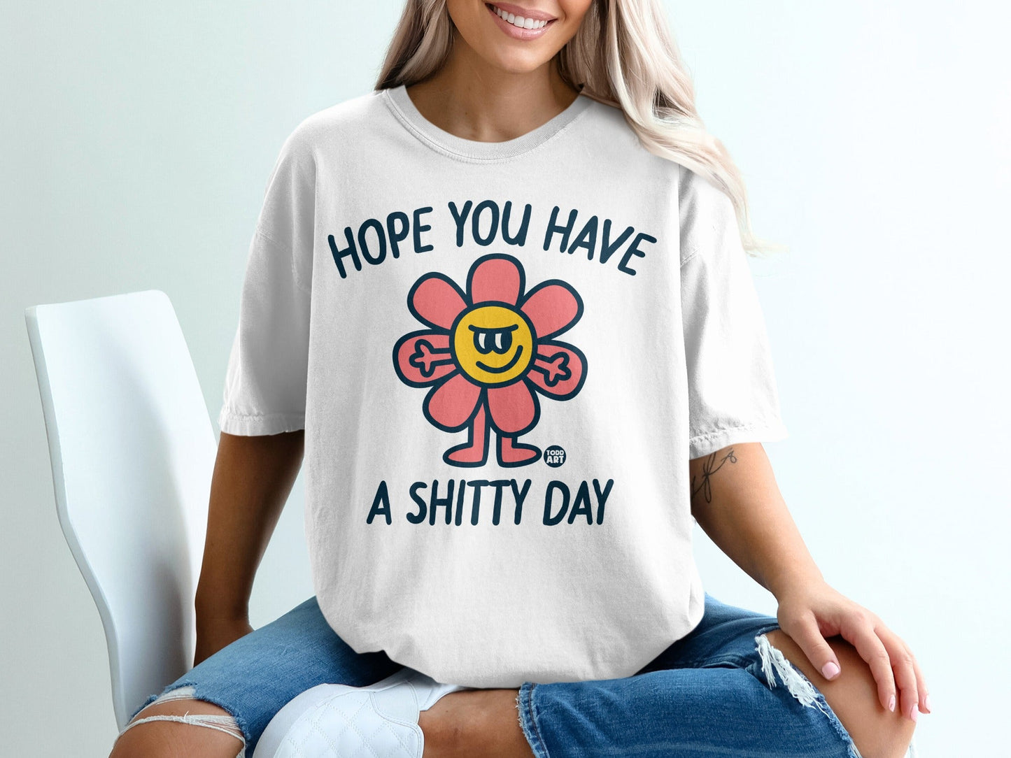 White t-shirt with flower graphic and "HOPE YOU HAVE A SHITTY DAY" text.
