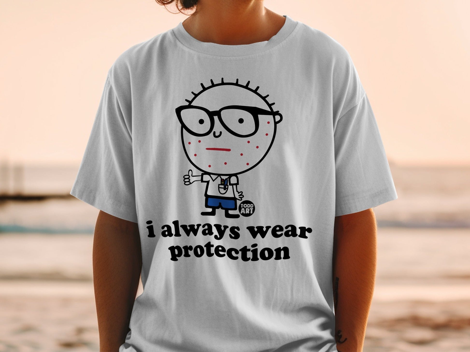 White t-shirt with cartoon character and "i always wear protection" text.