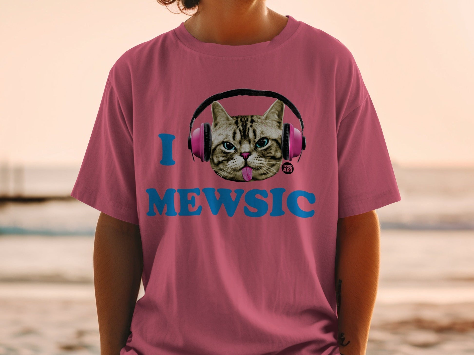 Pink t-shirt with cat wearing headphones and "I MEWSIC" text.