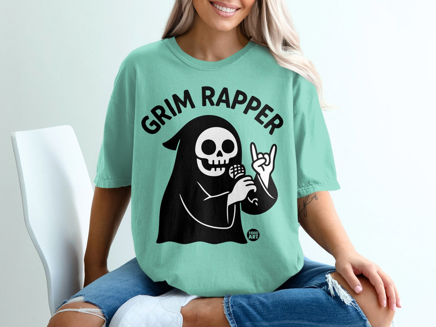 Grim Reaper character with "Grim Rapper" text on a teal t-shirt.