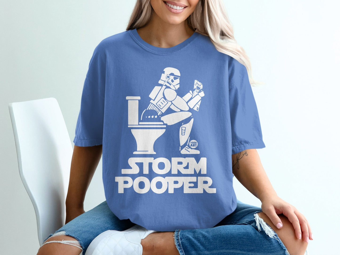 Stormtrooper sitting on a toilet, reading a phone, with "STORM POOPER" text.