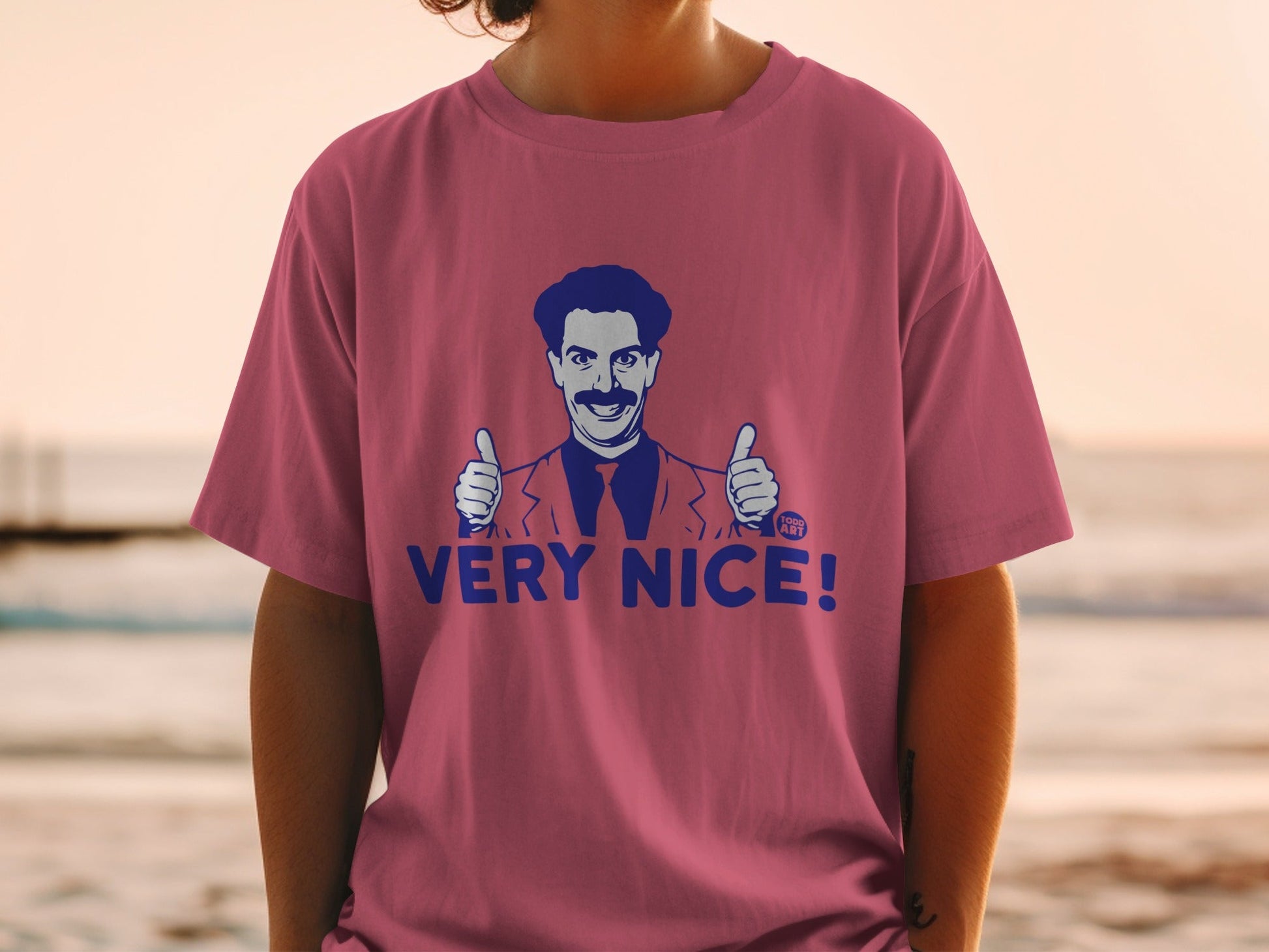 Borat giving two thumbs up with "VERY NICE!" text on a pink t-shirt.