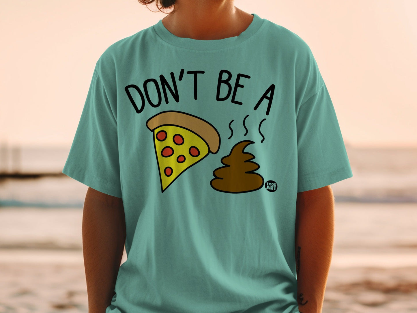 Turquoise t-shirt with "DON'T BE A" and pizza slice above brown poop.