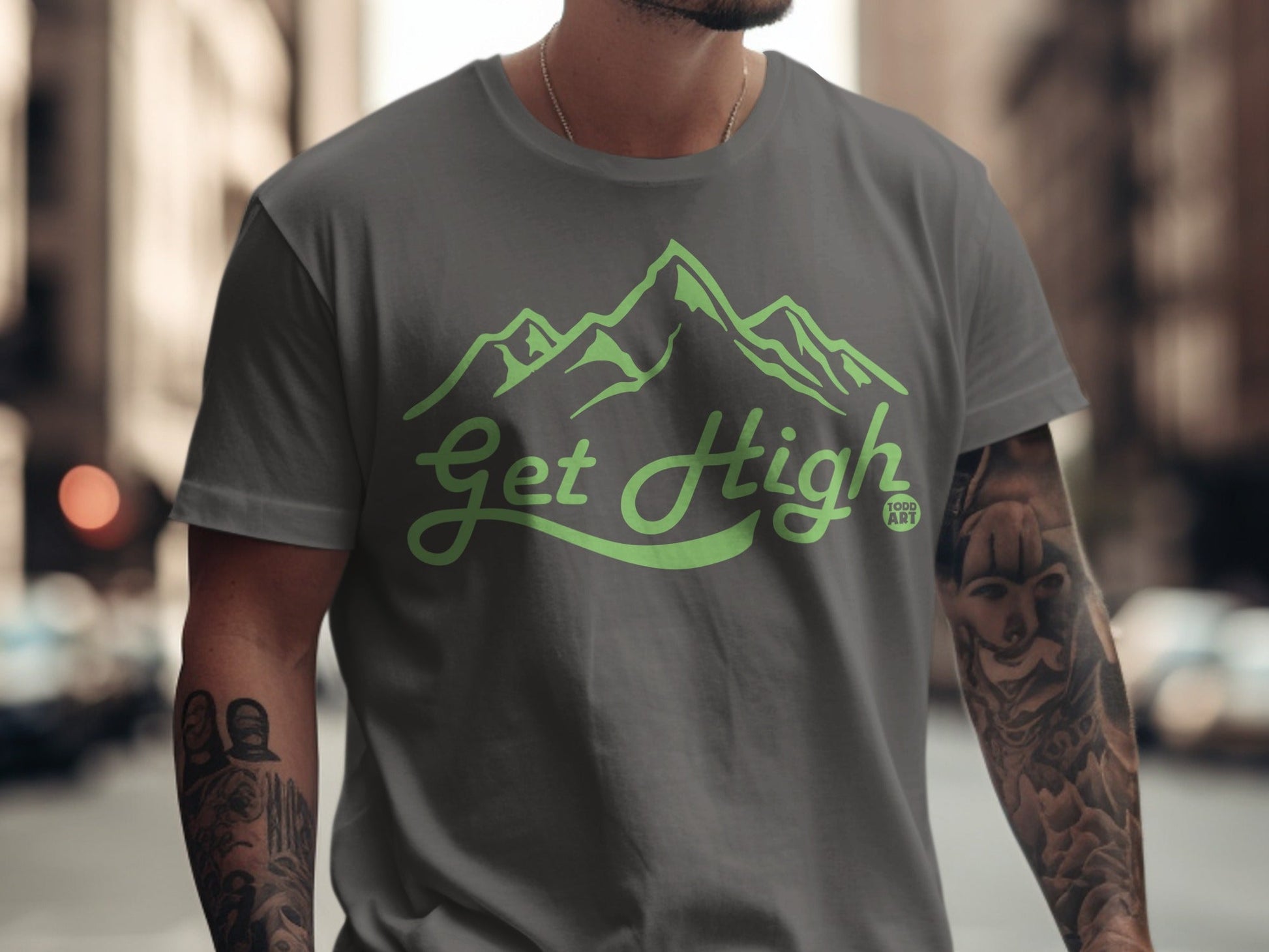 Gray t-shirt with "Get High" mountain logo and tattoo sleeves.