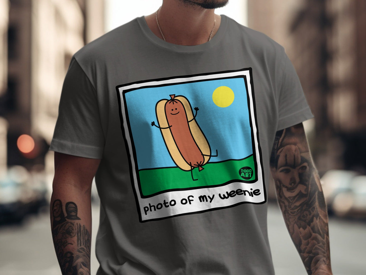 T-shirt featuring a cartoon hot dog with arms and legs, captioned "photo of my weenie".