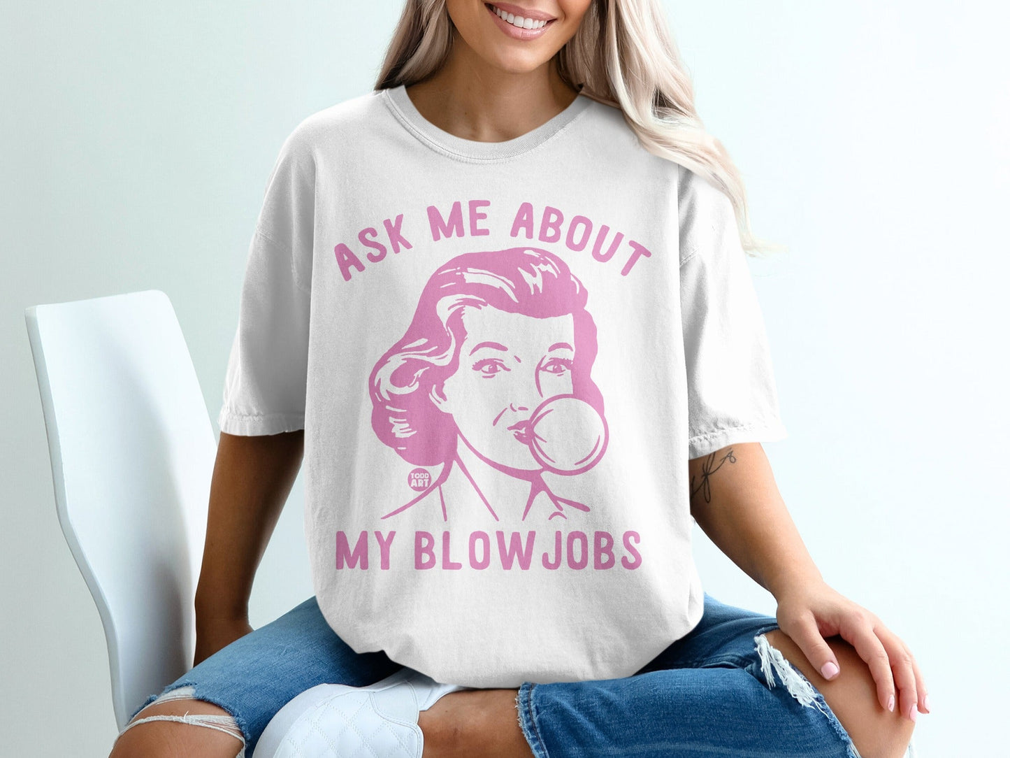 White t-shirt with pink retro graphic and text "Ask me about my blow jobs".