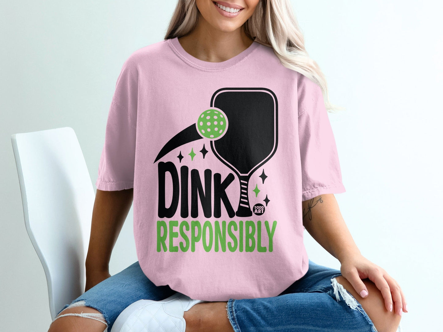 Pink t-shirt with "Dink Responsibly" text and pickleball graphic.
