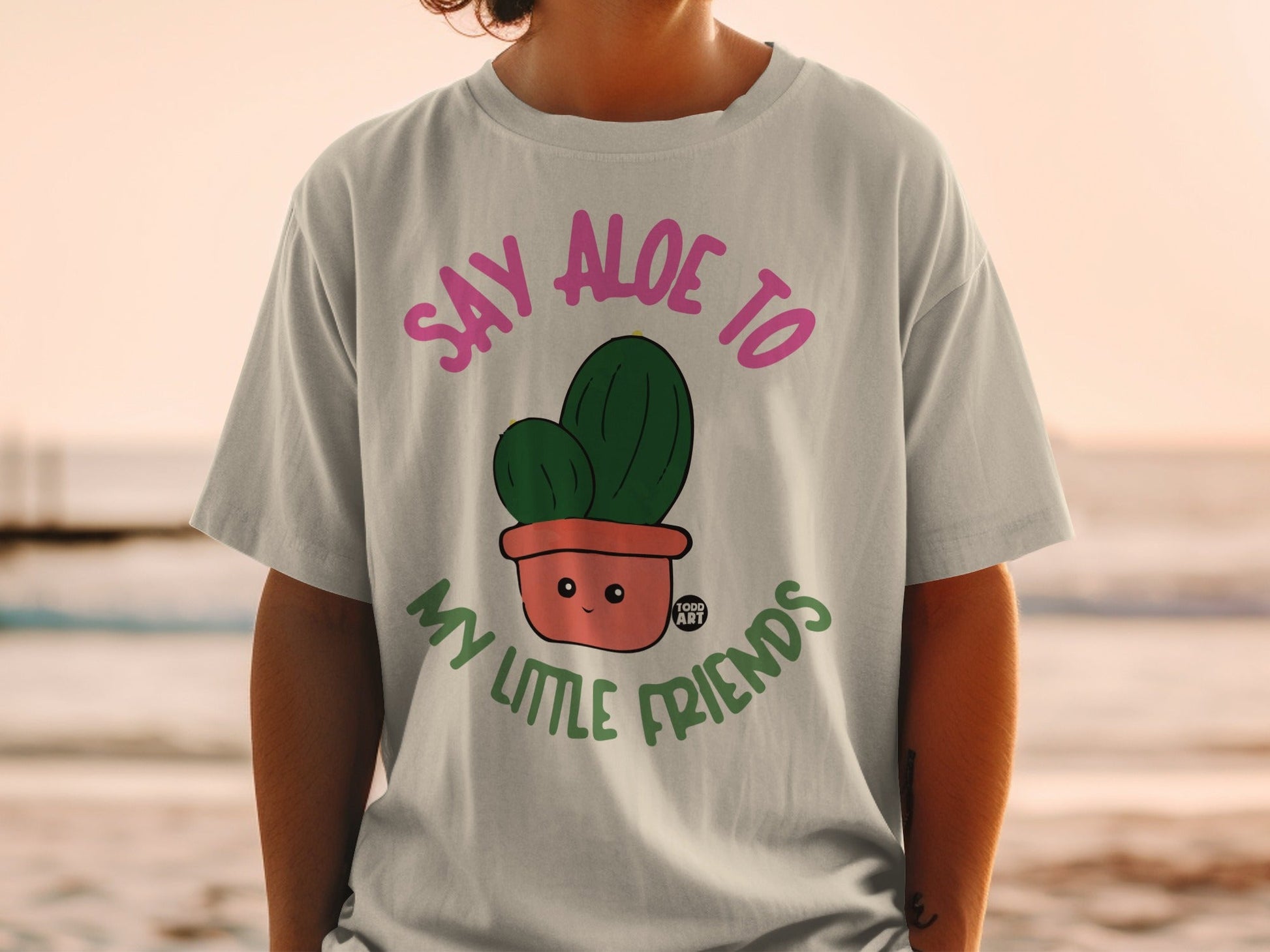 T-shirt with cartoon cactus in pot that says "Say aloe to my little friends."