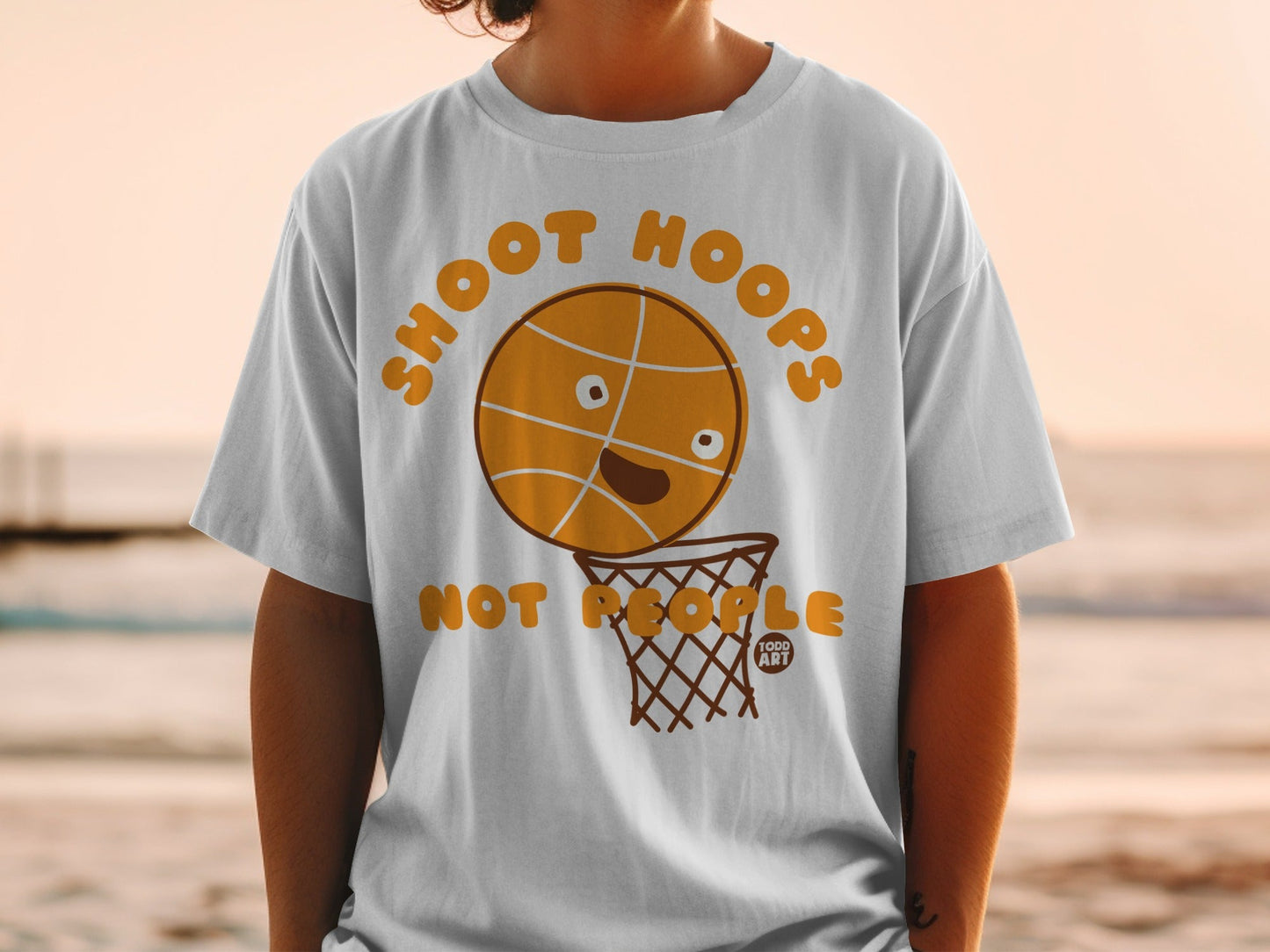 T-shirt with cartoon basketball saying "Shoot Hoops" above a basketball hoop.