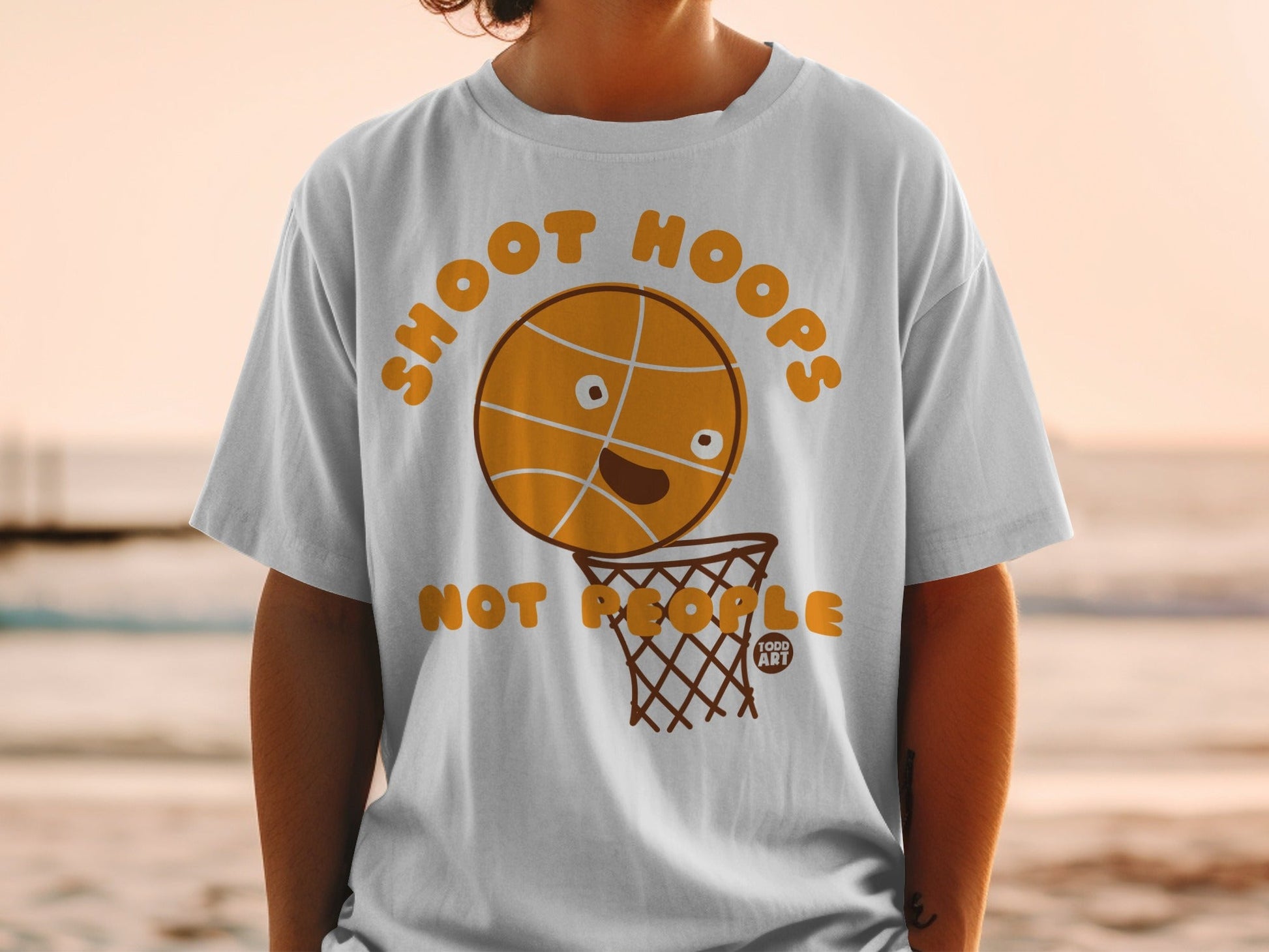 T-shirt with cartoon basketball saying "Shoot Hoops" above a basketball hoop.