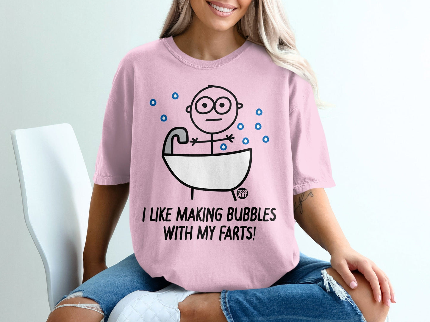 Pink t-shirt with cartoon figure in bathtub, "I like making bubbles with my farts!"