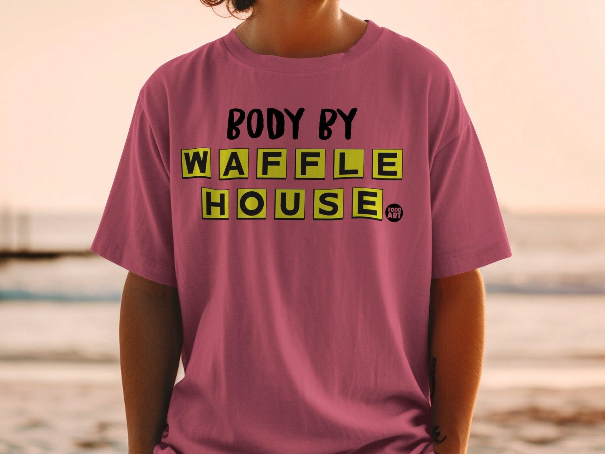 Pink t-shirt with "BODY BY WAFFLE HOUSE" text in yellow blocks.