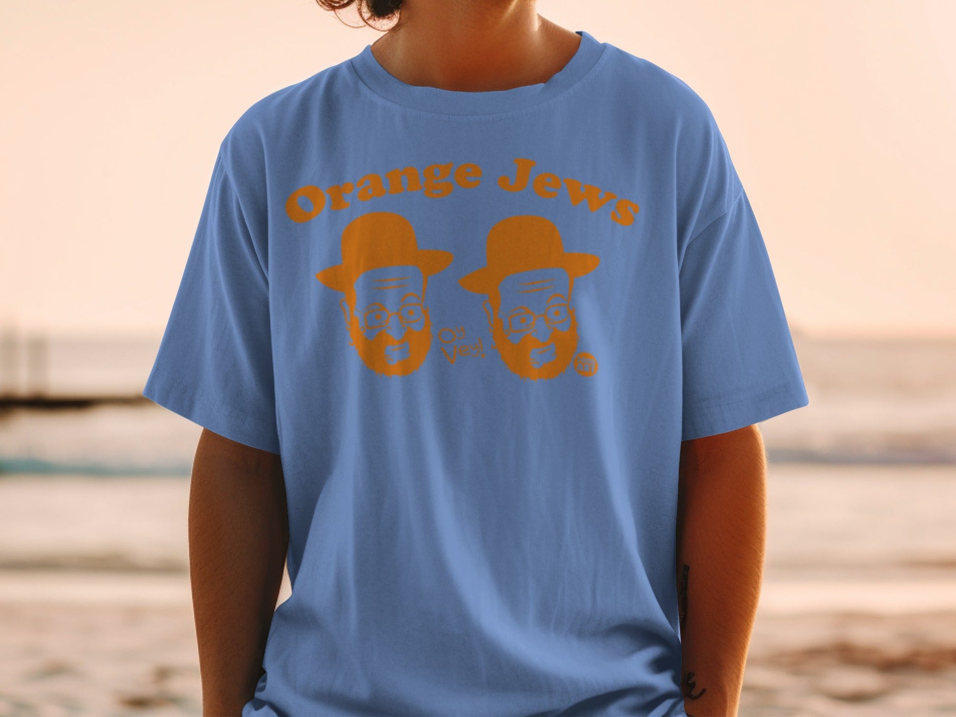 Blue t-shirt with orange text and caricatures of two men wearing hats.