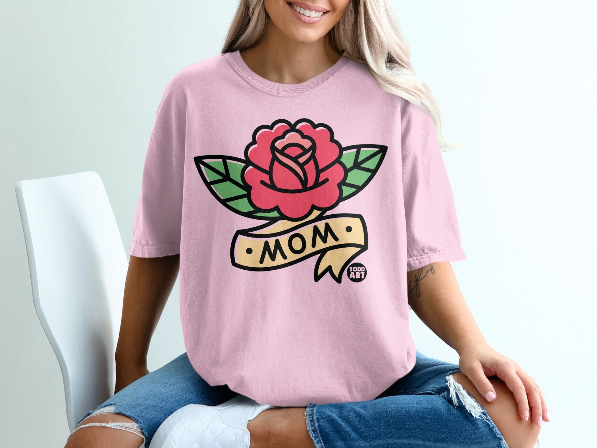 Pink t-shirt with a rose and banner tattoo design that says "MOM".