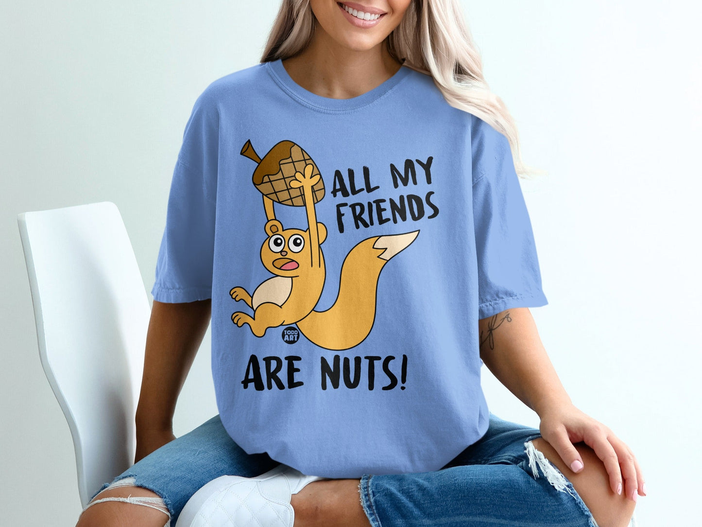 Blue t-shirt with a cartoon squirrel holding an acorn and text "All my friends are nuts!".
