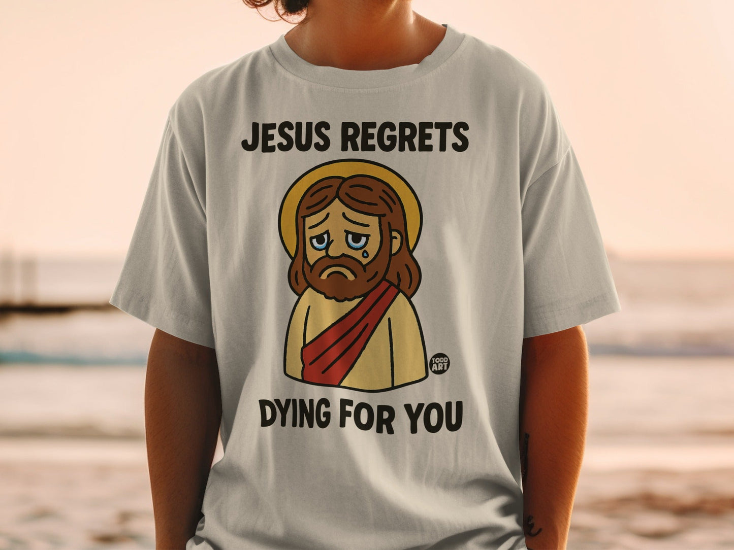 T-shirt with cartoon Jesus crying and text "Jesus regrets dying for you".
