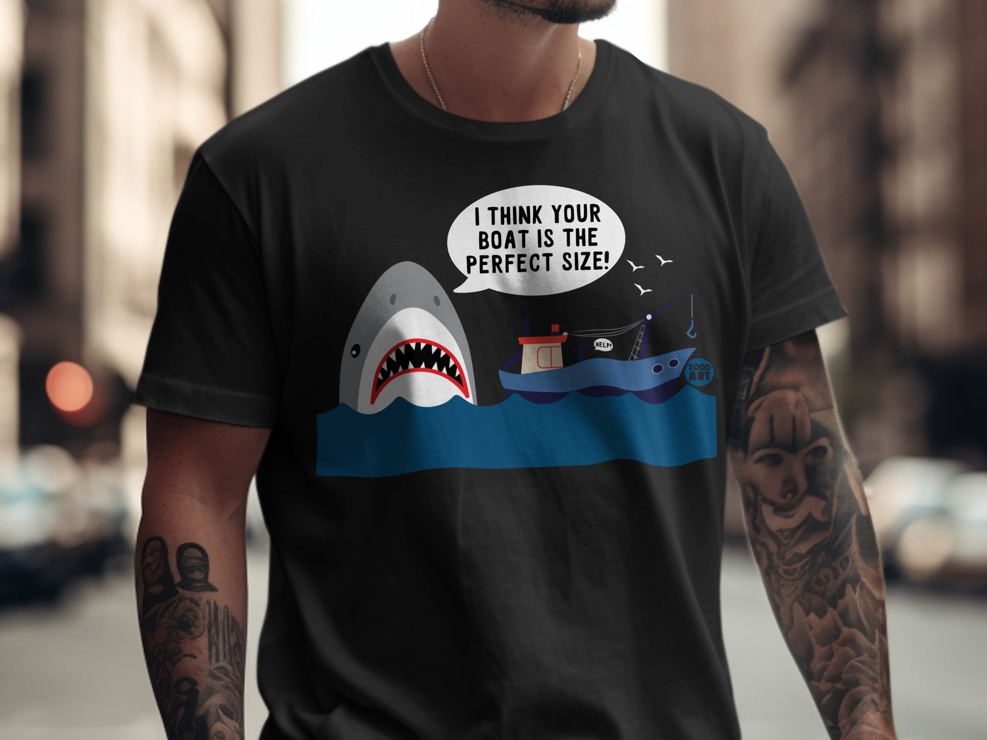 T-shirt with shark, boat, and "I THINK YOUR BOAT IS THE PERFECT SIZE!" text.