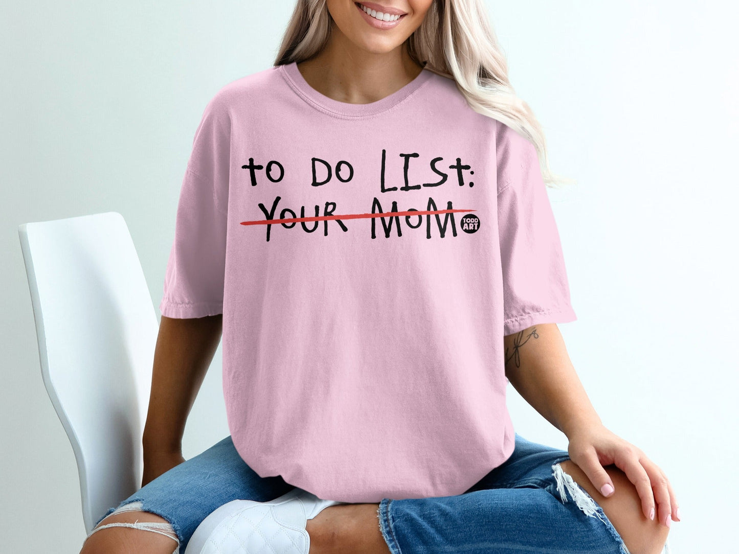 Pink t-shirt with "TO DO LIST: YOUR MOM" printed in black, with a red line through "YOUR MOM".