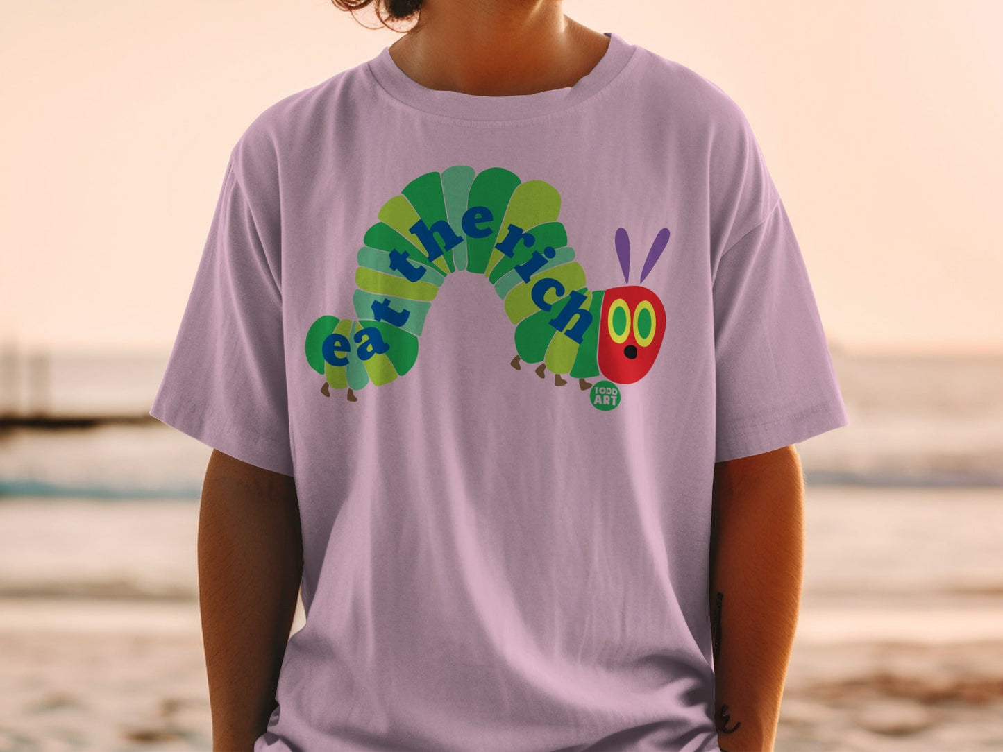 Purple t-shirt with a colorful, smiling caterpillar eating the words "eat the rich."