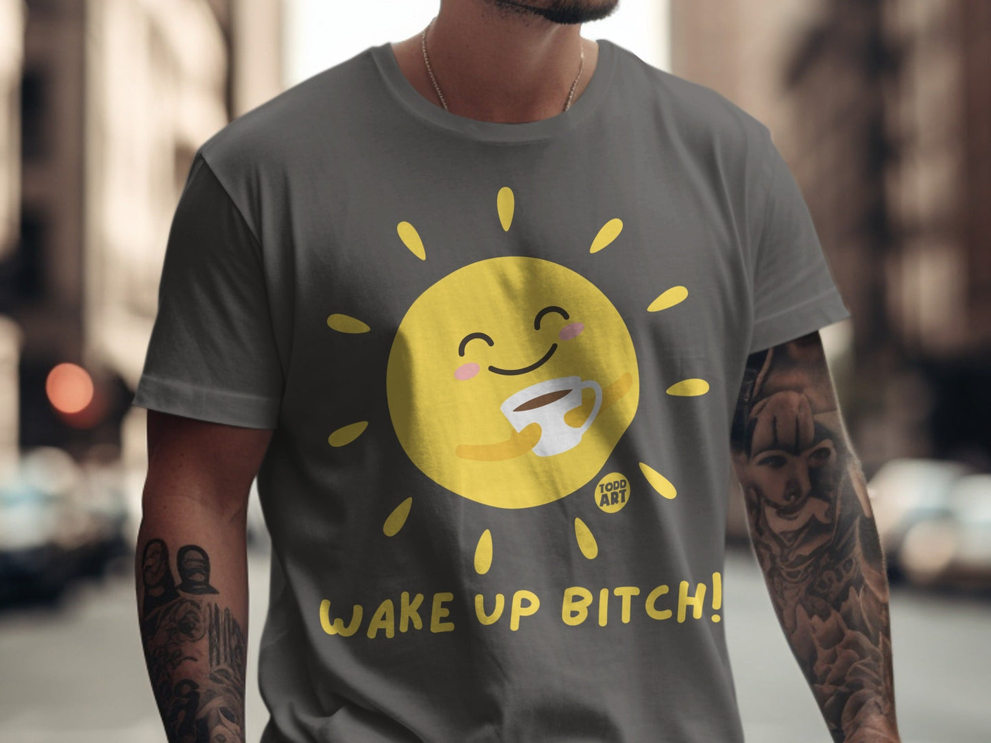 Grey t-shirt with a smiling sun holding a coffee cup and text "Wake Up Bitch!".