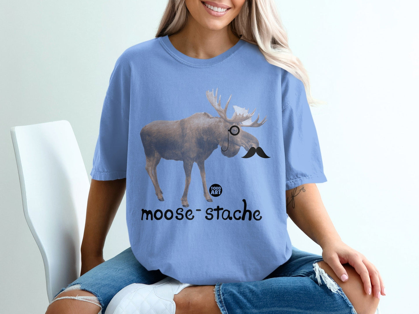 Moose wearing a monocle and mustache, "moose-stache" text below.