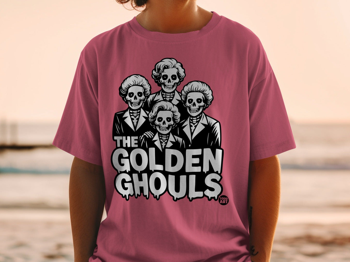 Pink t-shirt featuring four skeletons in suits with "The Golden Ghouls" text.