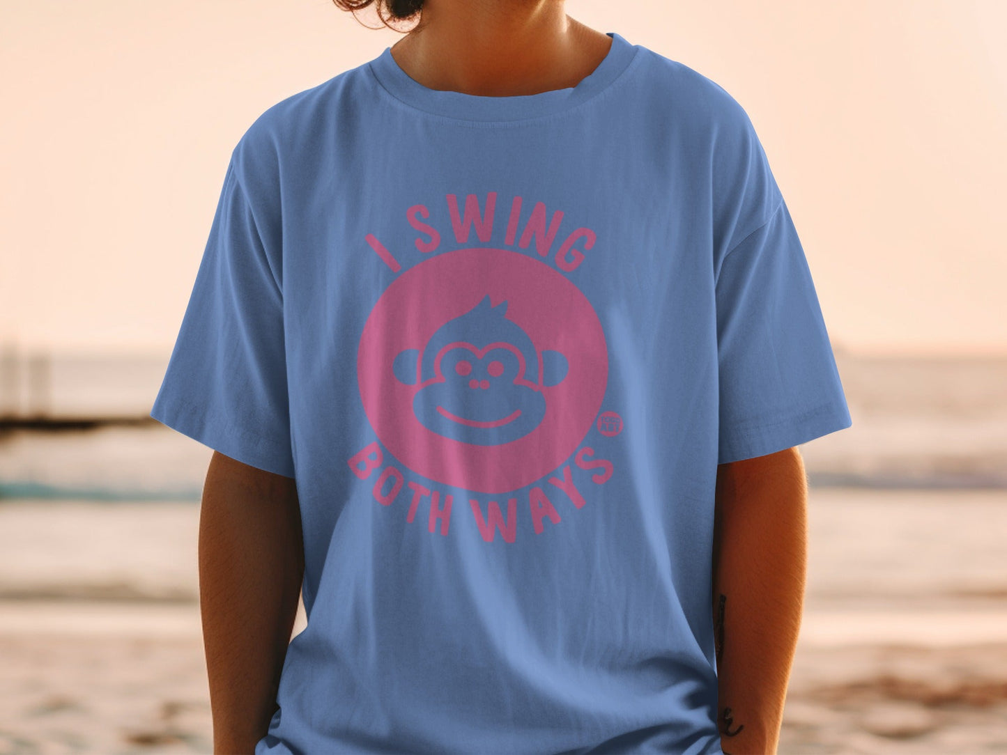 Pink monkey face with "I SWING BOTH WAYS" text on a blue t-shirt.