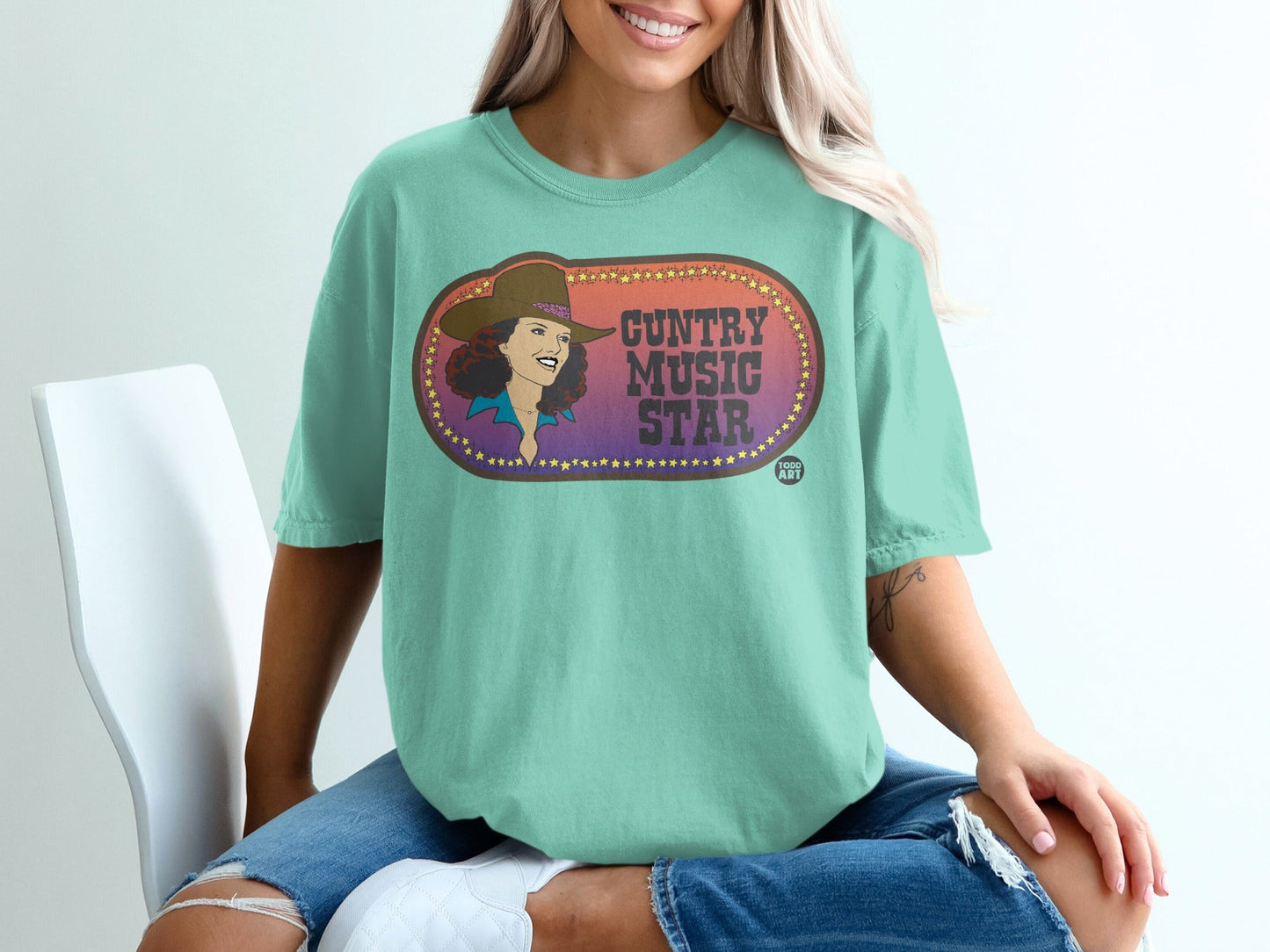 Mint green t-shirt with "GUNT'RY MUSIC STAR" text and a woman in a cowboy hat.