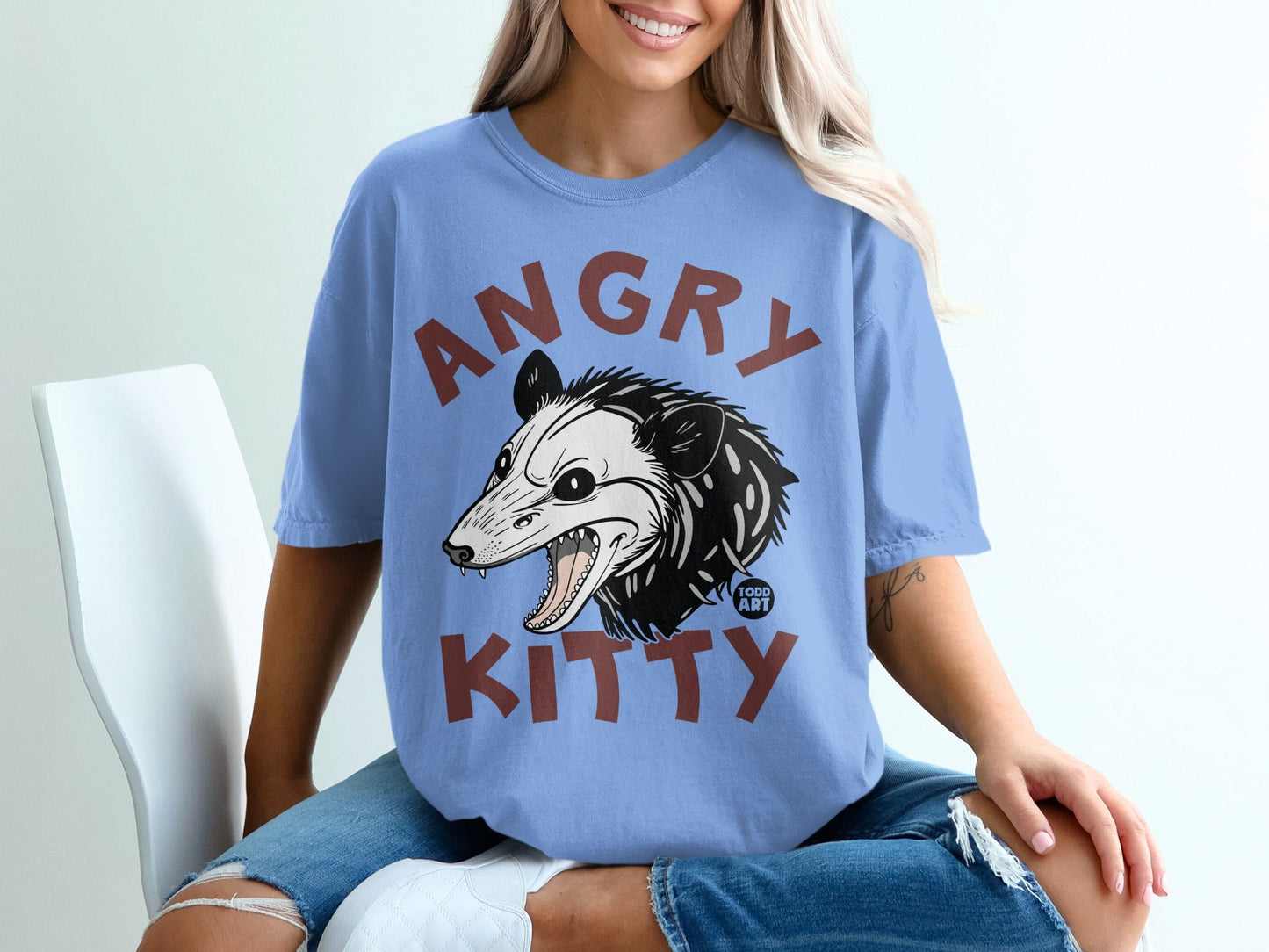 Blue t-shirt with "ANGRY KITTY" text and a cartoon opossum graphic.