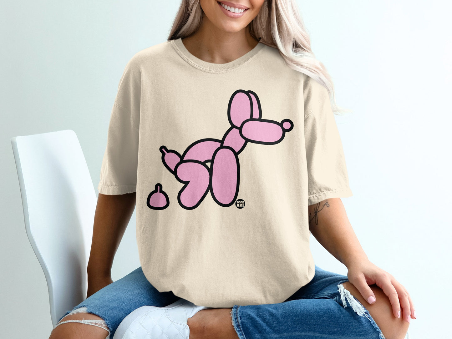 T-shirt with a pink balloon dog and small pile.