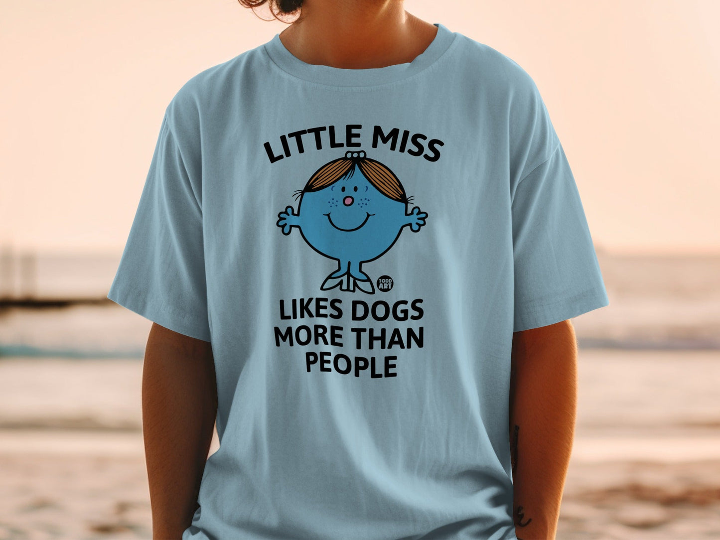 Light blue t-shirt with "Little Miss Likes Dogs More Than People" graphic.