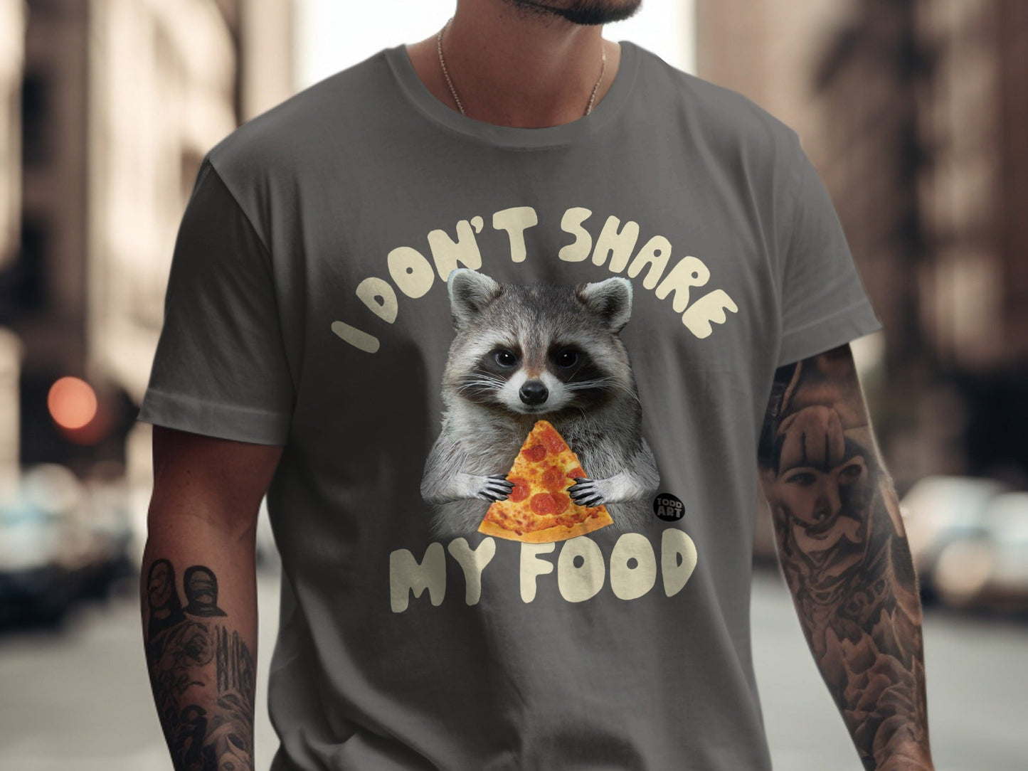 T-shirt with raccoon holding slice of pizza and text "I don't share my food".