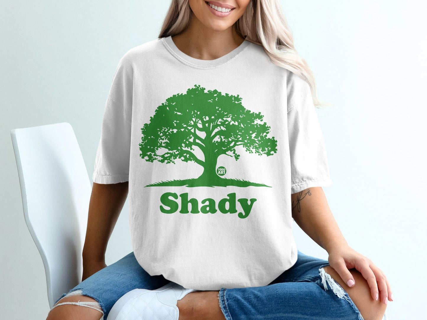 White t-shirt with green tree graphic and "Shady" text.